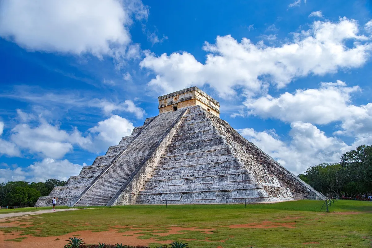 La pyramide de Kukulcán à Chichén Itzá sous un ciel bleu nuageux, au Yucatán